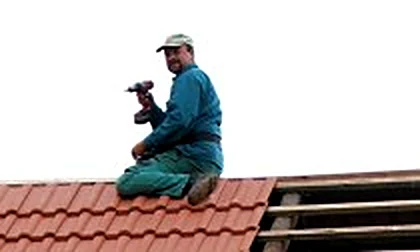 Pokrývač při pokládce tašek na střeše